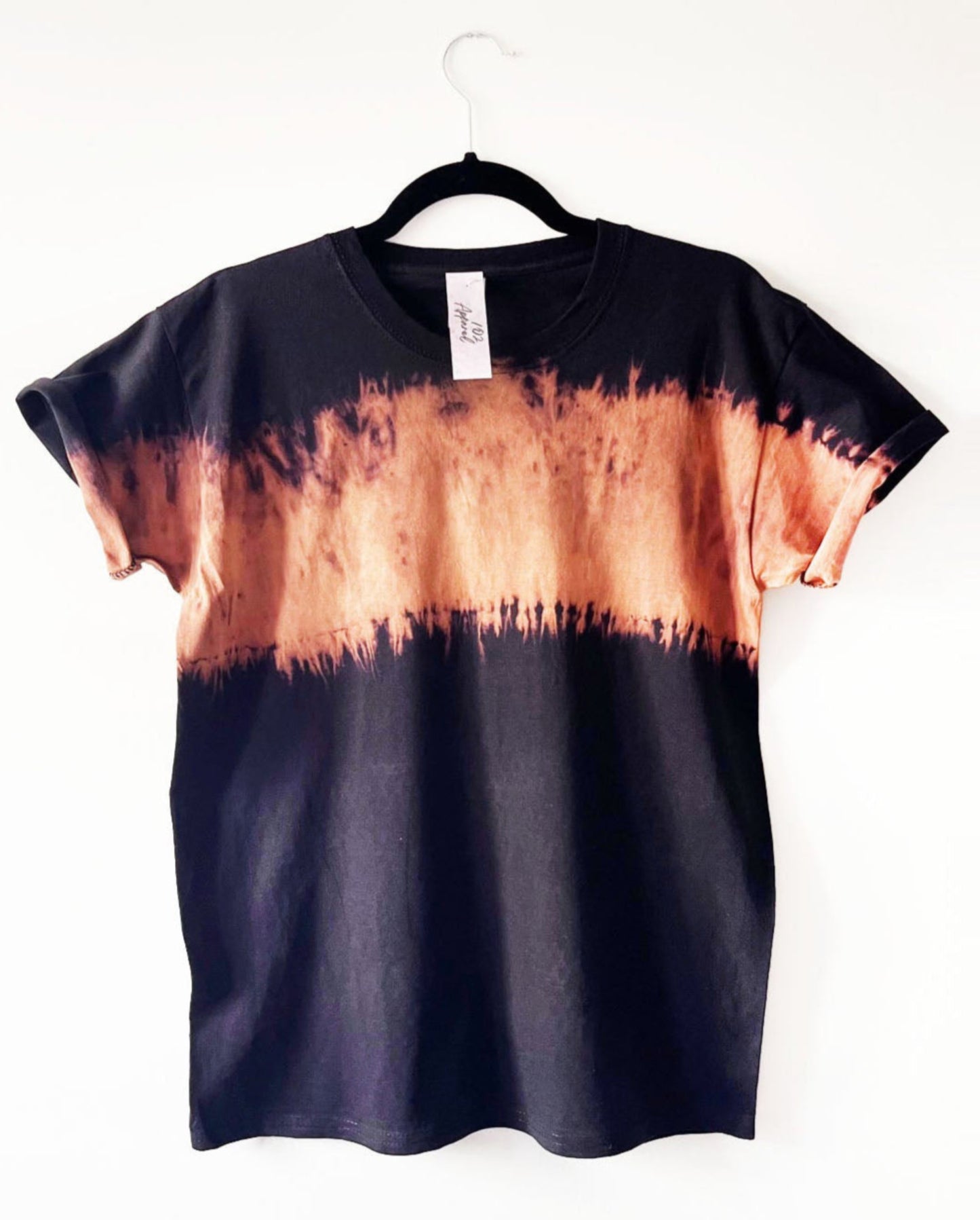 a black t crewneck t shirt with a band of orange bleach tie dye