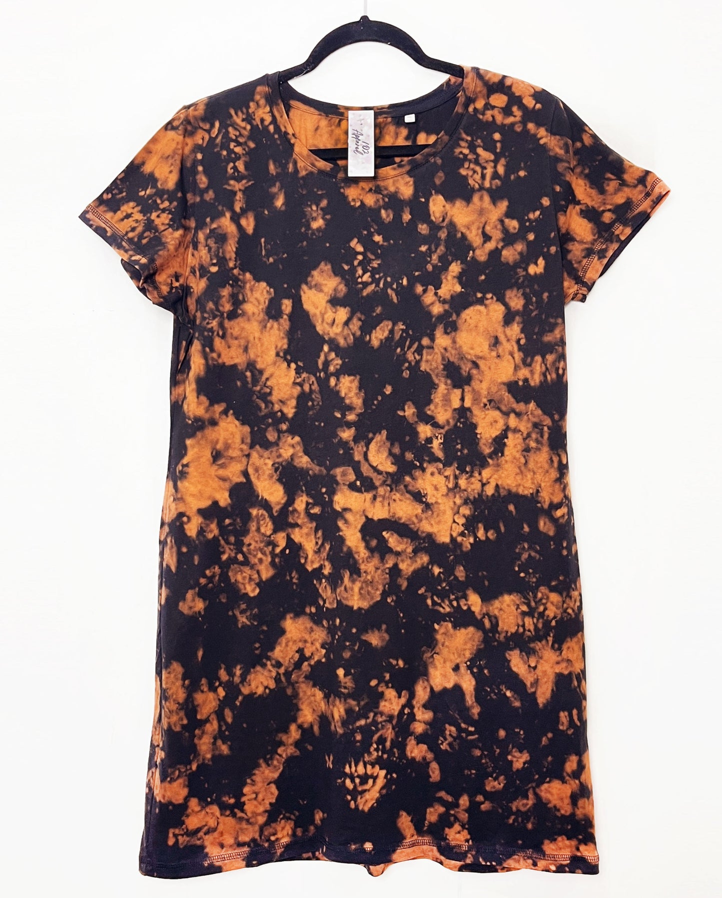 a black t shirt dress with short sleeves and orange bleached tie dye pattern