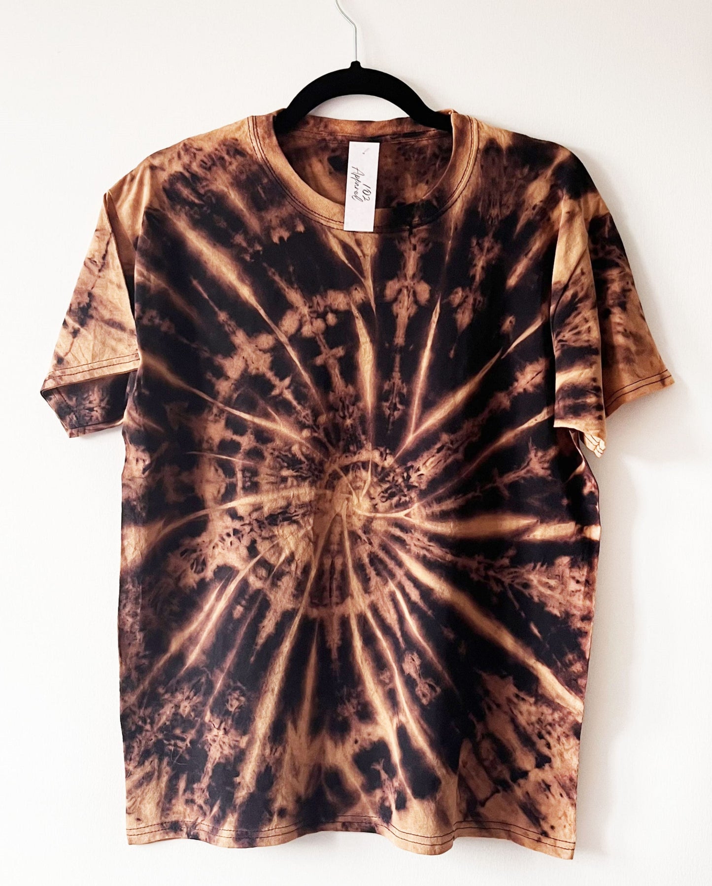 black short sleeve crewneck t shirt with an orange / copper spiral / swirl design