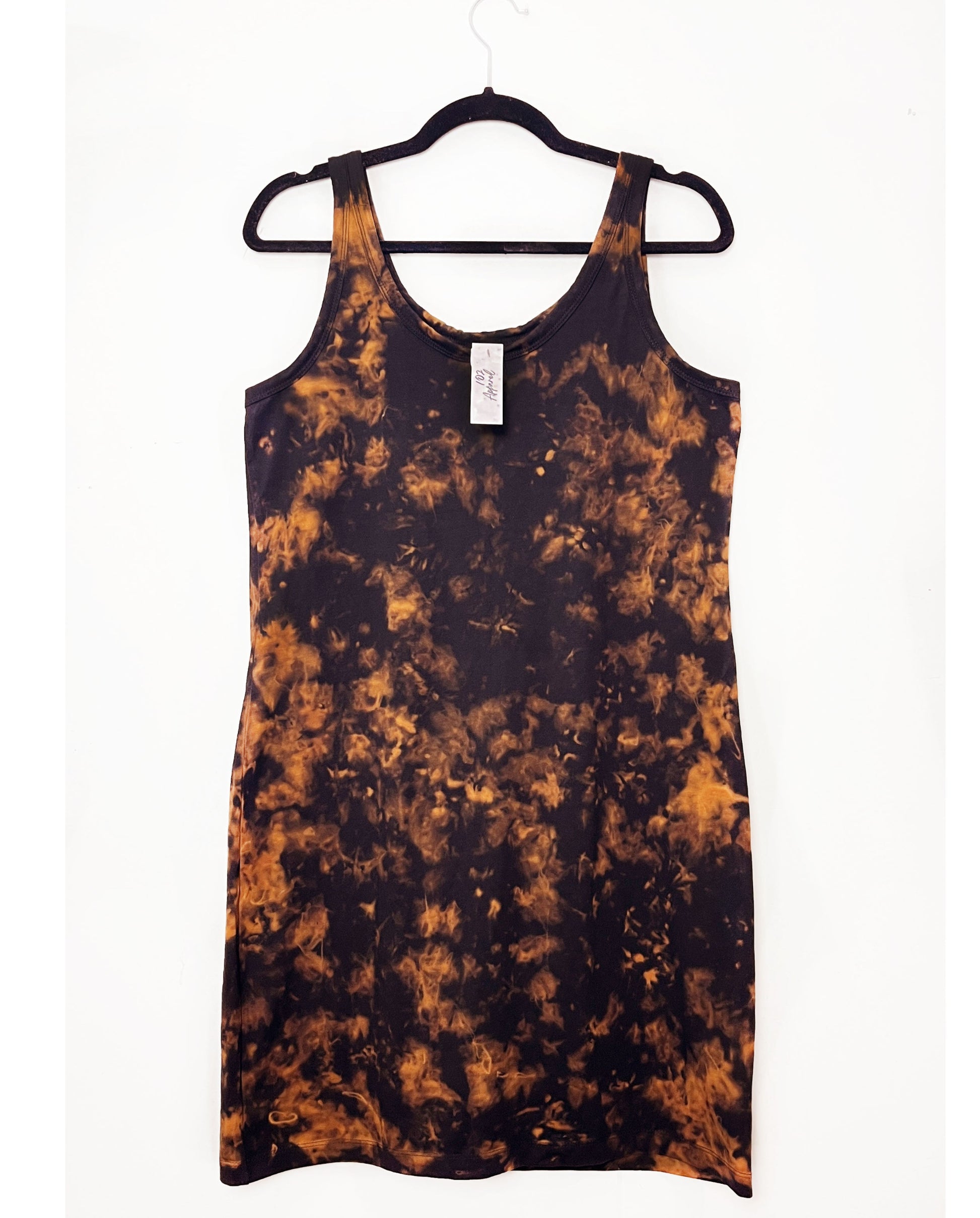 a black strappy dress in a tank top style with orange bleach tie dye pattern