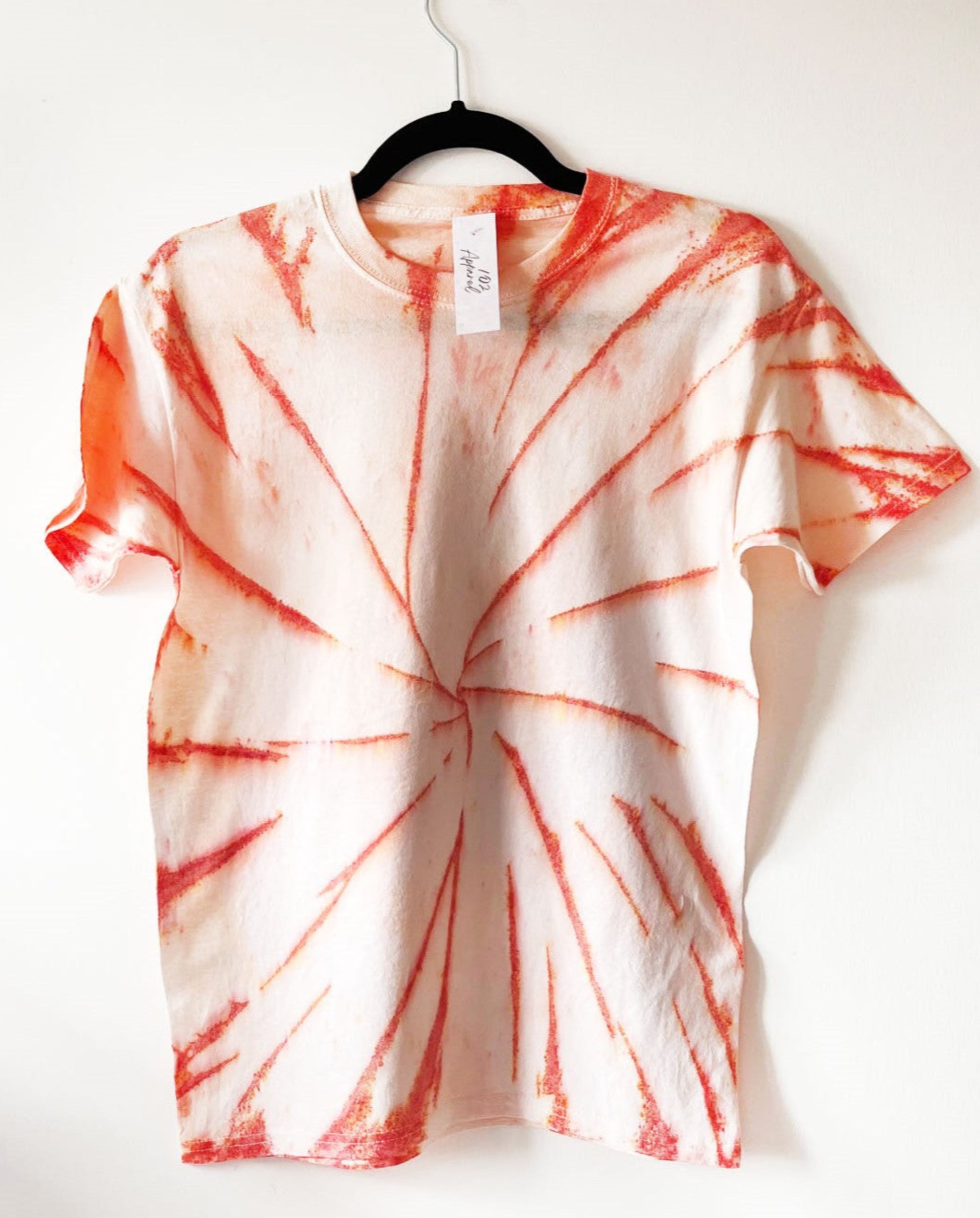 white crewneck t shirt with spiral design in orange, orange speckled swirl